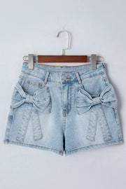 Light wash denim shorts with bow embellishments on pockets and button fly.