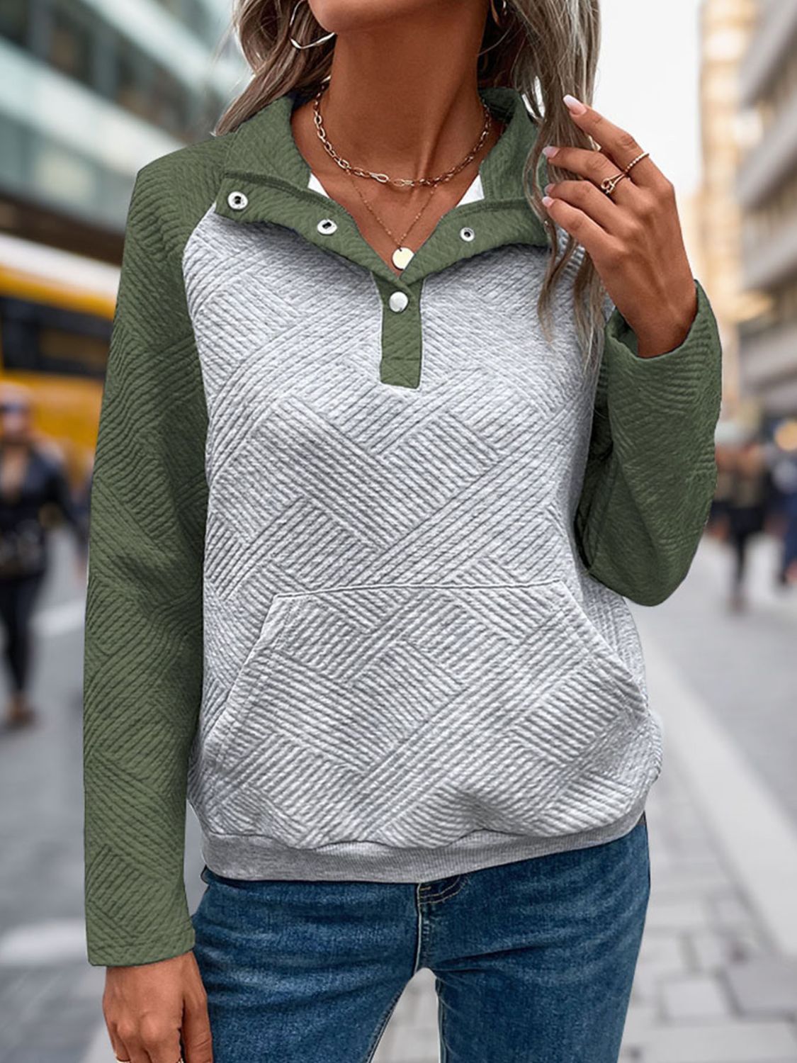 Quilted raglan henley sweatshirt in moss green and gray with button detail and front pocket.