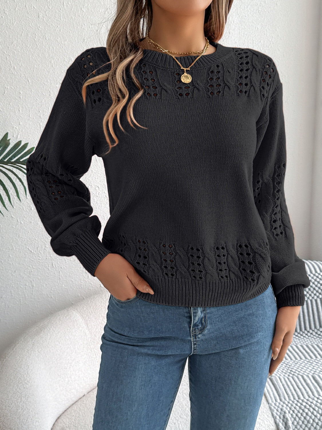 Black openwork knit sweater with cable detail on sleeves and hem
