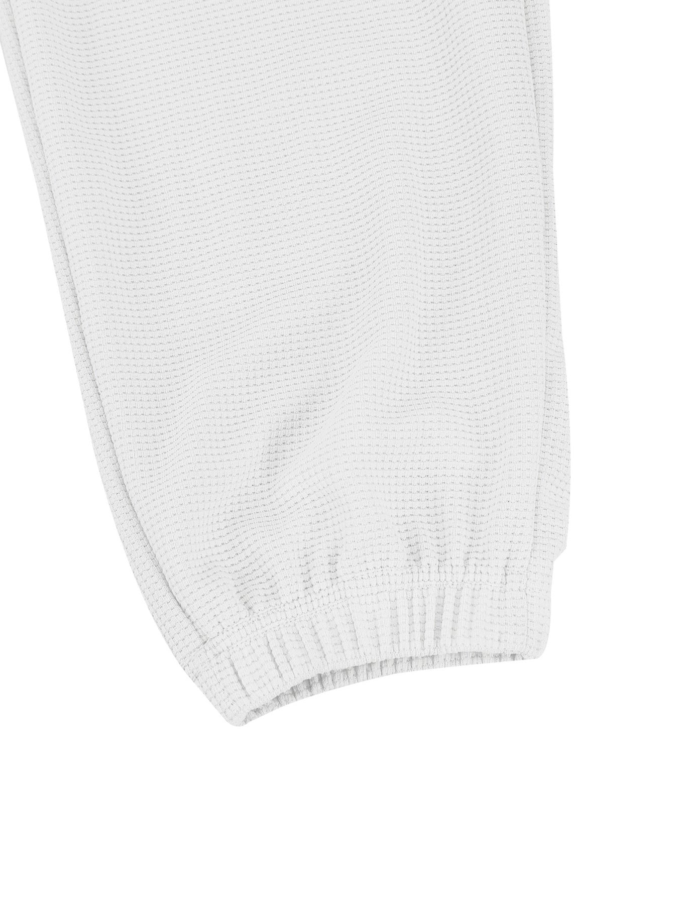 White waffle knit joggers with elastic cuffs and drawstring detail.