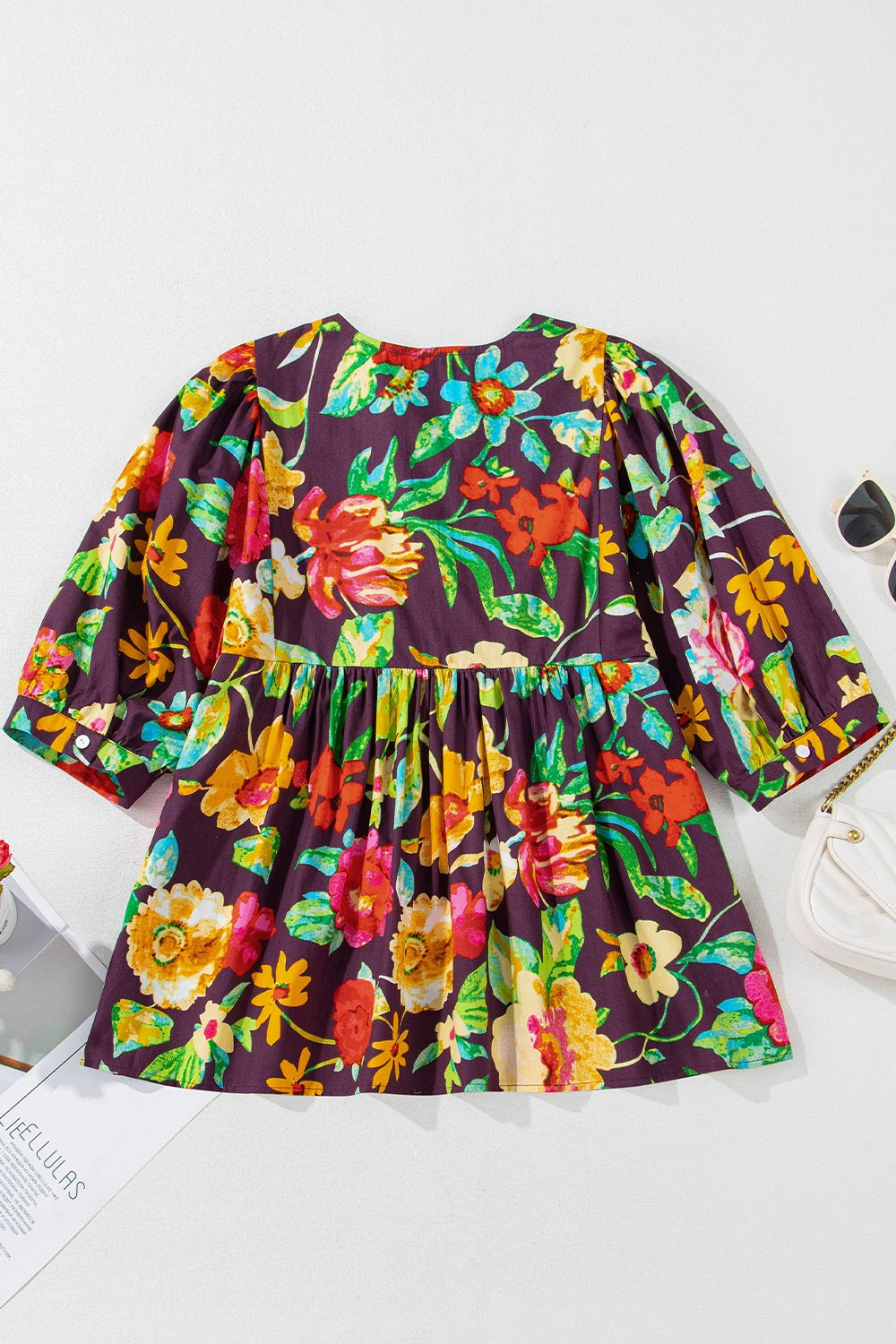 Embroidered floral babydoll blouse with puff sleeves and gathered waist.