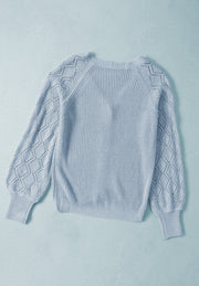 Light blue knit cardigan with diamond-cut sleeves and ribbed cuffs.