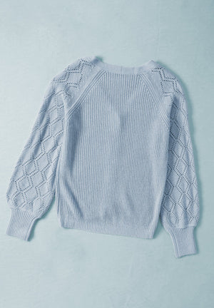 Light blue knit cardigan with diamond-cut sleeves and ribbed cuffs.