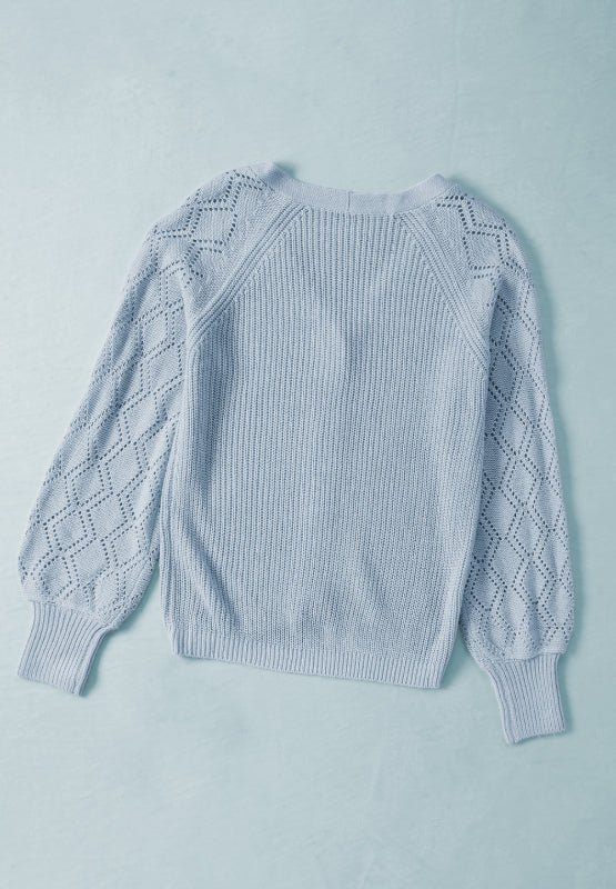 Light blue knit cardigan with diamond-cut sleeves and ribbed cuffs.
