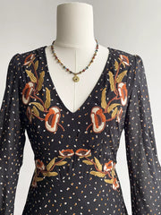 Black maxi dress with embroidered floral detail and polka dot print.