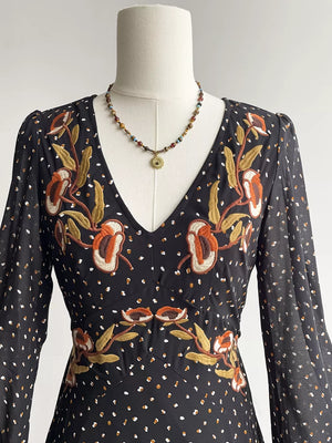 Black maxi dress with embroidered floral detail and polka dot print.