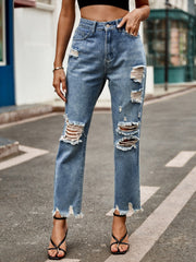 Medium wash denim jeans with ripped knees and raw hem straight leg cut.