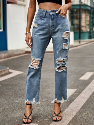 Medium wash denim jeans with ripped knees and raw hem straight leg cut.