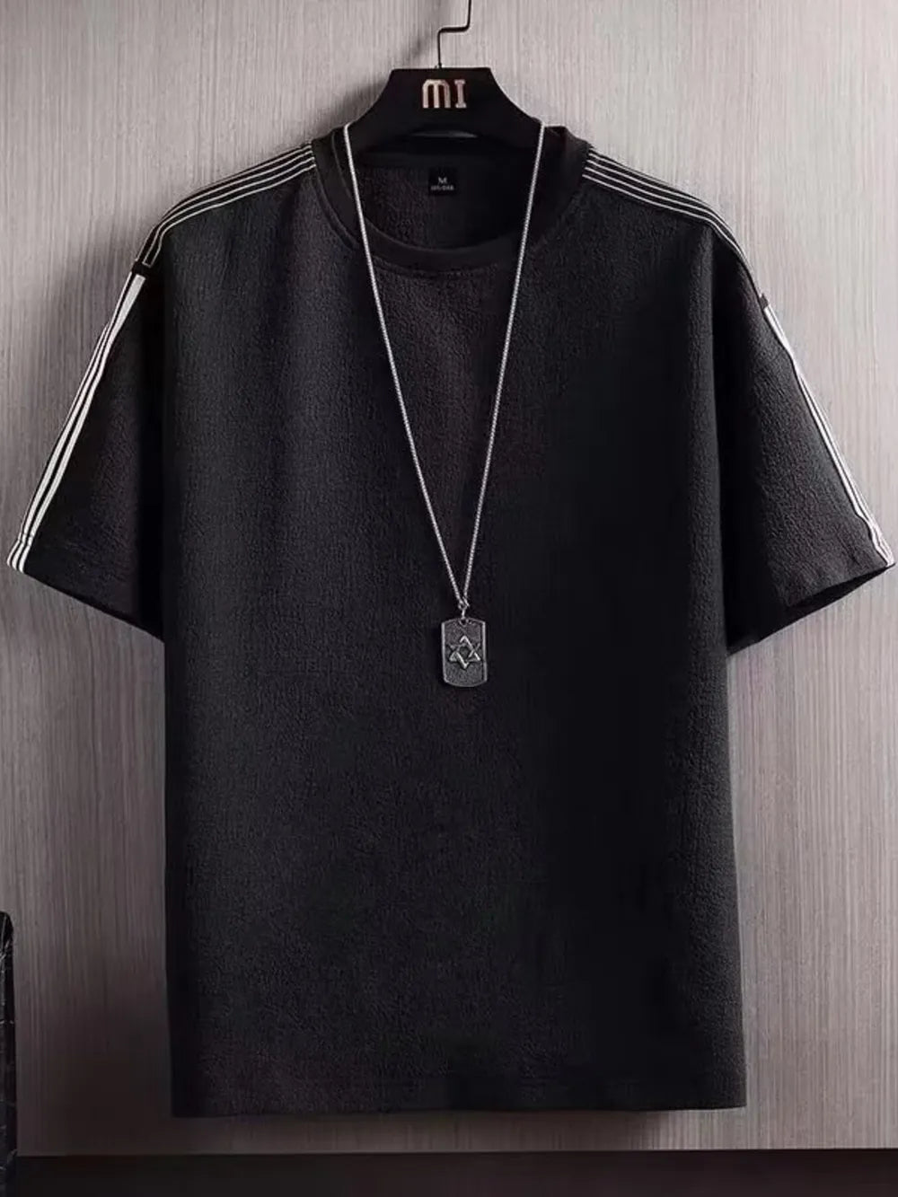 Black textured t-shirt for men with white stripe detail on sleeves and round neck.