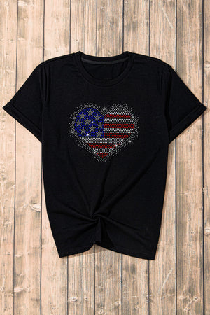 Black t-shirt with rhinestone American flag heart graphic and twisted hem.