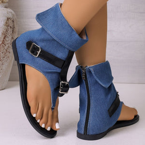 Blue denim gladiator sandals with black buckle straps and side zippers.