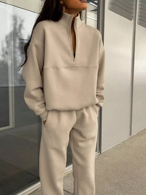 Tan half zip sweatshirt and matching sweatpants set with a high neckline and relaxed fit.