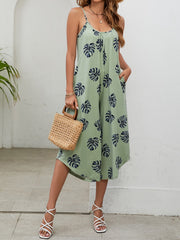 Sage green culotte jumpsuit with monstera print, gathered bust, and spaghetti straps.