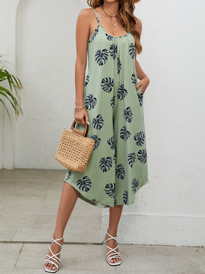 Sage green culotte jumpsuit with monstera print, gathered bust, and spaghetti straps.