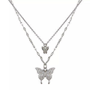 Elegant double-layer necklace with two butterfly charms, one encrusted with stones, in white gold color.