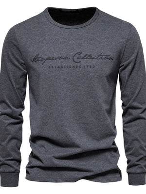 Dark gray crewneck long sleeve t-shirt with embroidered "Aspen Collection Established 1980" graphic.