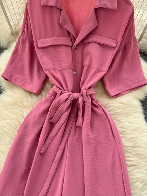 Pink belted wide-leg maternity jumpsuit with pockets and button front.
