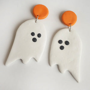 White ghost drop earrings with orange tops and black dot eyes, perfect for Halloween.
