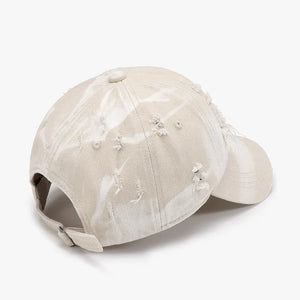 Shredded canvas baseball cap in ivory with distressed details and a tie-dye effect.