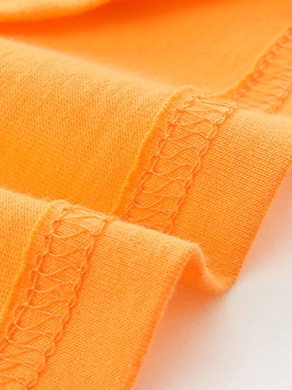 Orange cotton t-shirt detail showing hem stitching