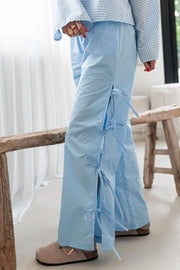 Light blue palazzo trousers with side tie details and slits.