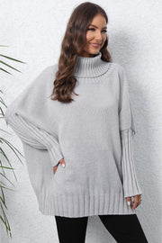 Light Gray ribbed knit turtleneck sweater with batwing sleeves and ribbed cuffs.