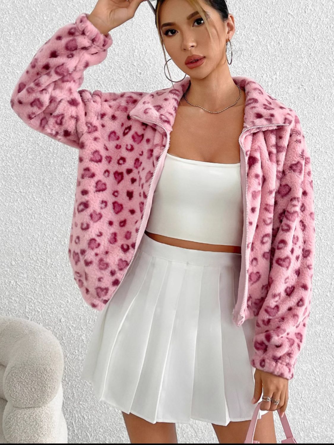 Blush pink faux fur zip track jacket with a heart pattern, featuring a collar and long sleeves.