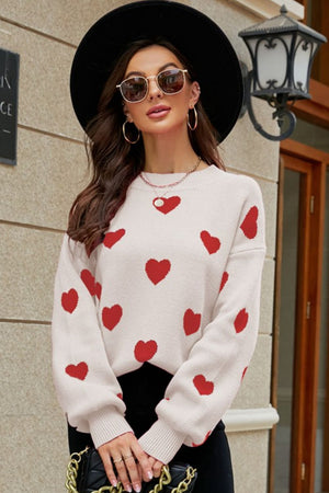 Beige knit sweater with red heart pattern, crew neck, and balloon sleeves.