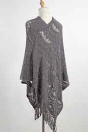 Dark gray crochet poncho with intricate openwork pattern and fringe detail.