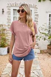 Perforated sleeve tee in blush pink with rolled cuffs and a textured pattern.