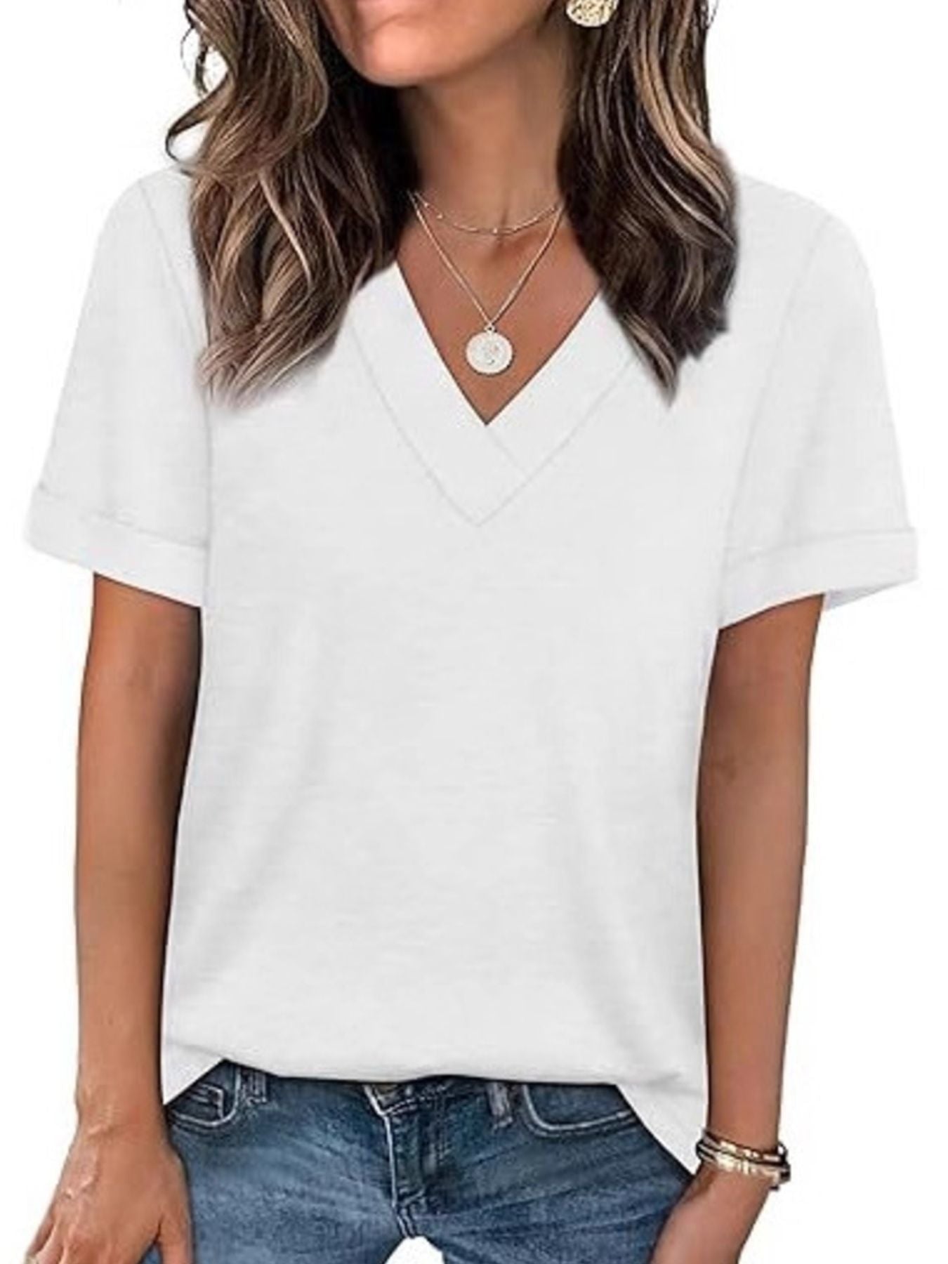White V-neck t-shirt with cuffed short sleeves, styled with jeans and necklaces.