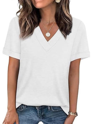 White V-neck t-shirt with cuffed short sleeves, styled with jeans and necklaces.