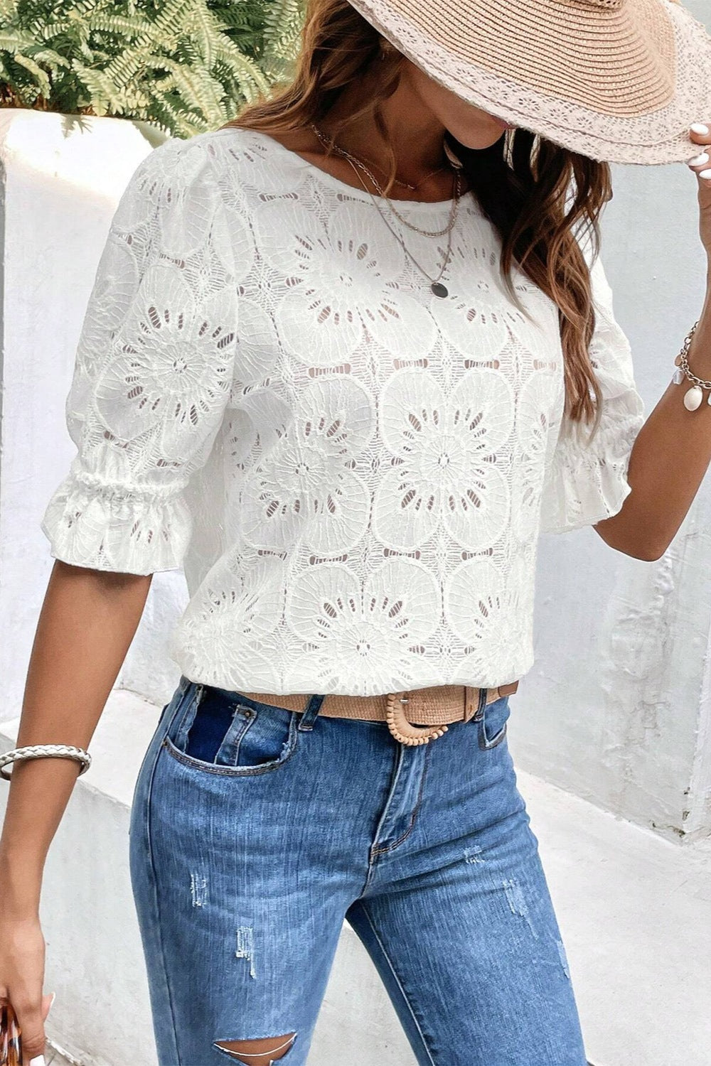 White eyelet blouse with puff sleeves and ruffled cuffs.