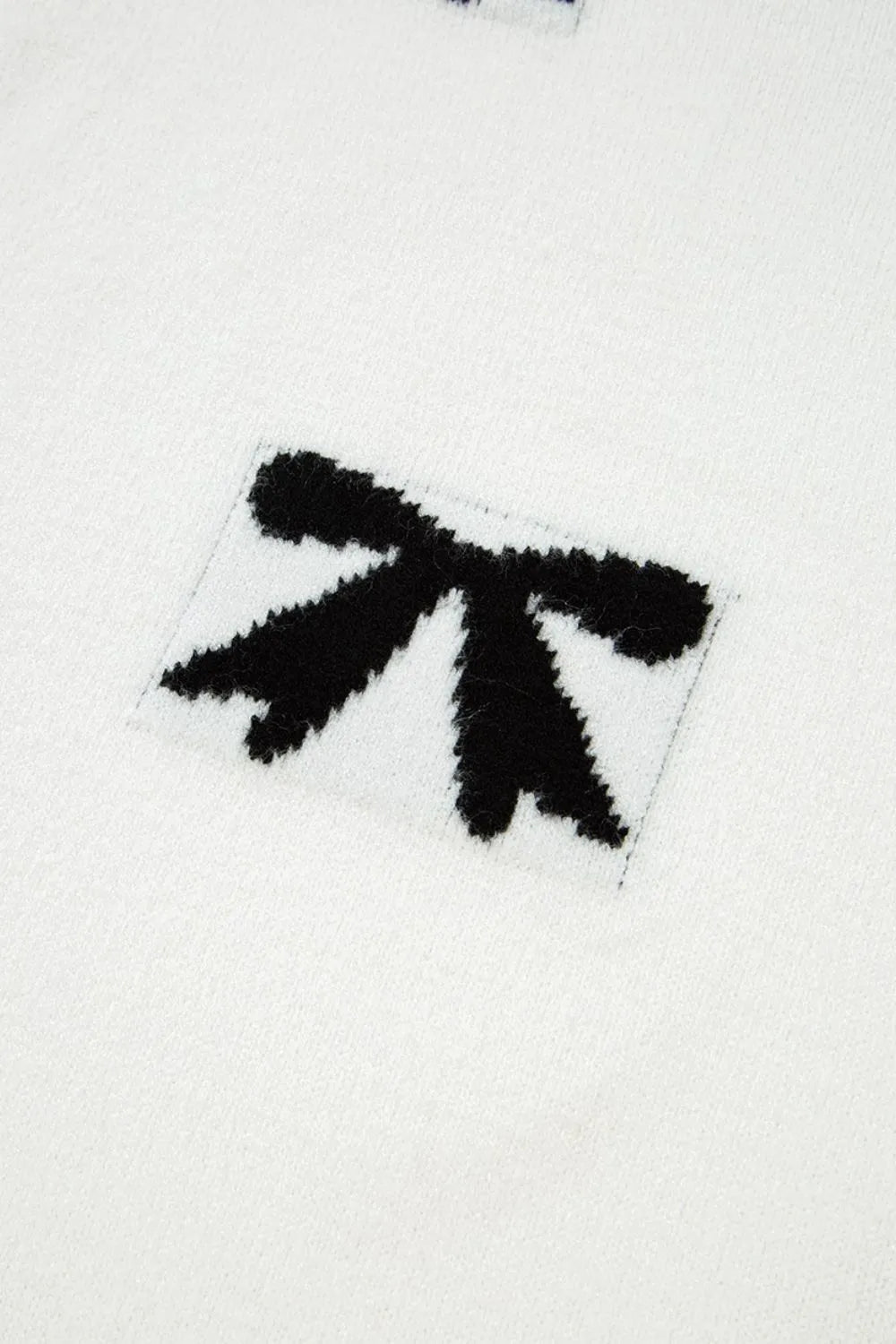 White knit tunic with black bow motif detail