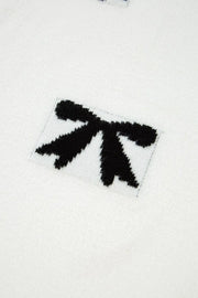 White knit tunic with black bow motif detail