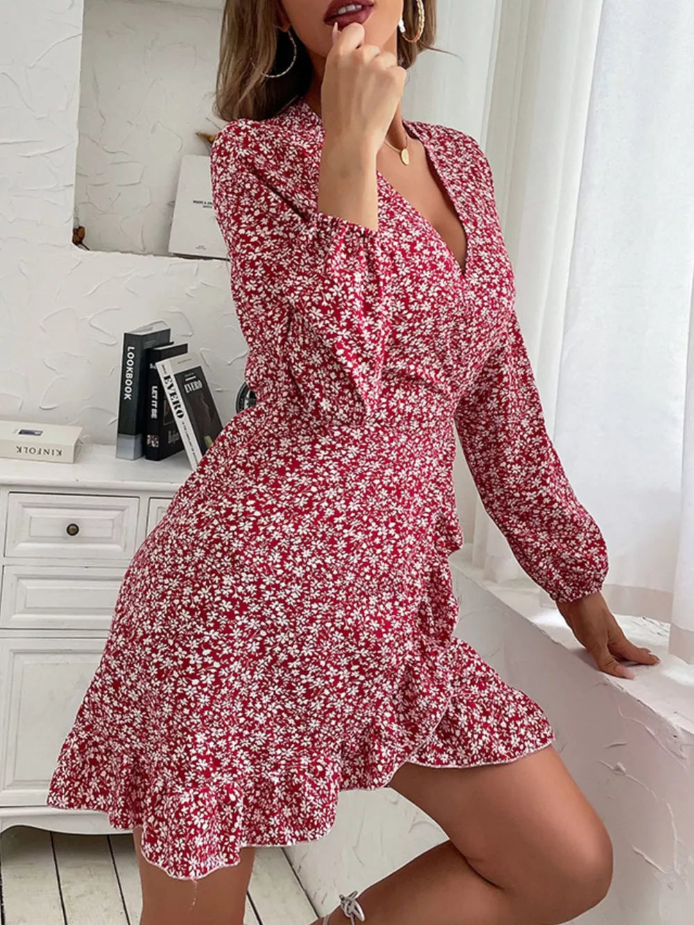 Red floral wrap mini dress with V-neck, long sleeves, and ruffled hem.