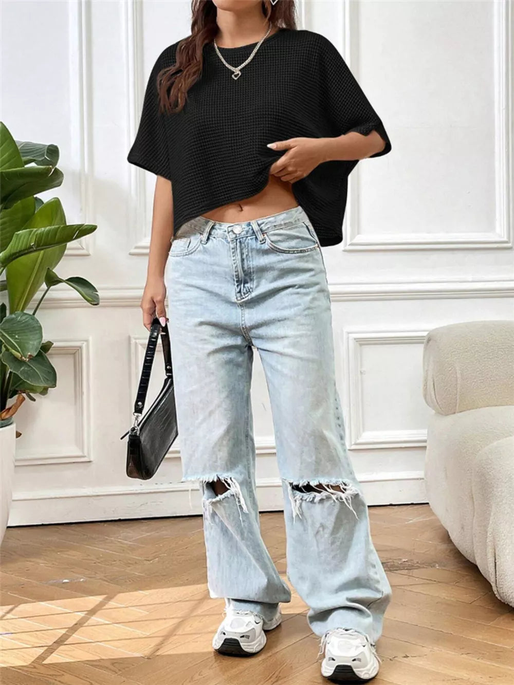 Black waffle-knit cropped t-shirt with crew neck and short sleeves.