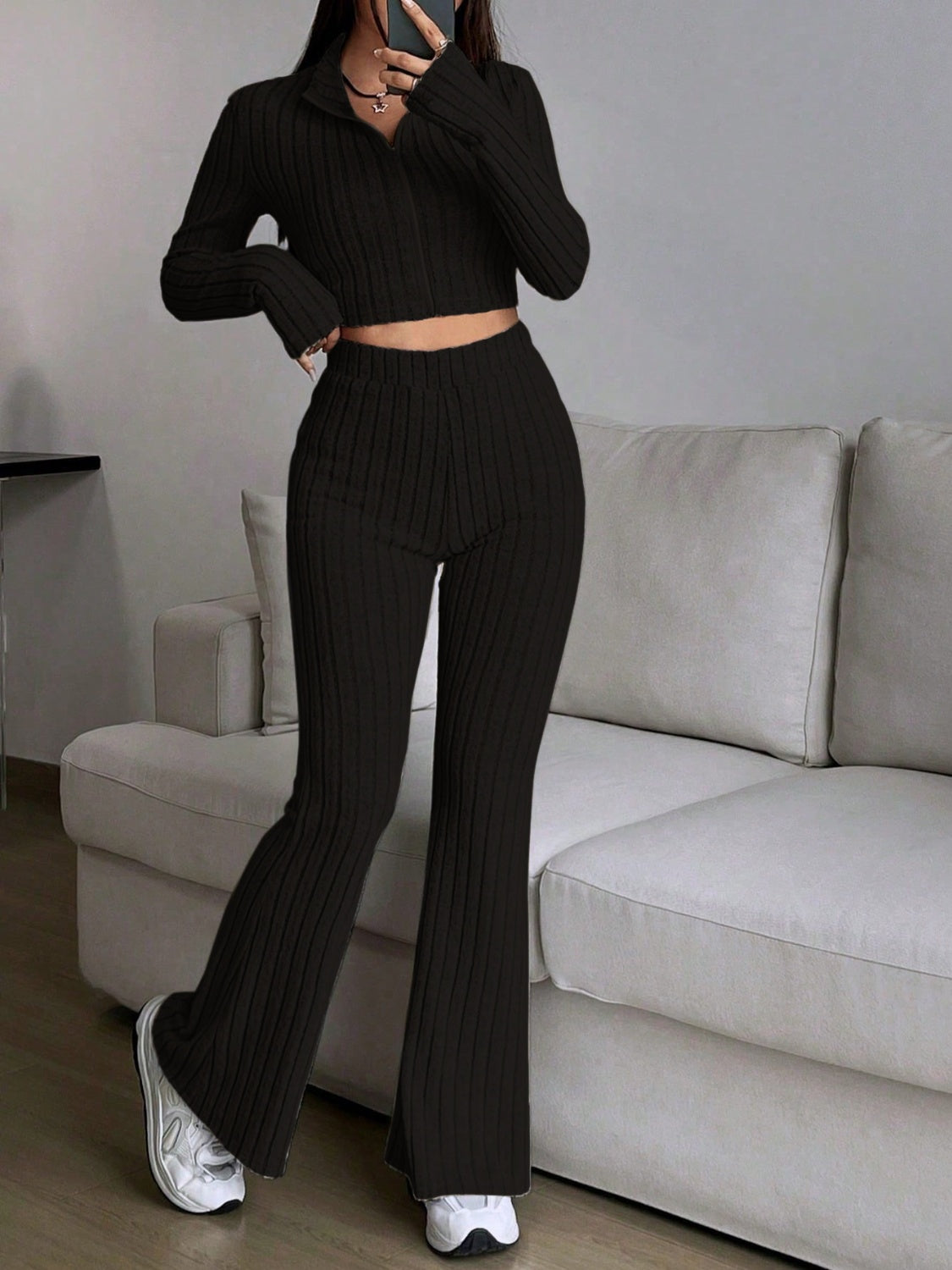 Black ribbed knit flare co-ord set with zip-neck crop top and high-waisted pants.