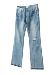 Split-hem distressed denim jeans in medium wash with raw hem detail.