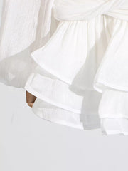 White ruffle mini dress with balloon sleeves and a twisted detail.