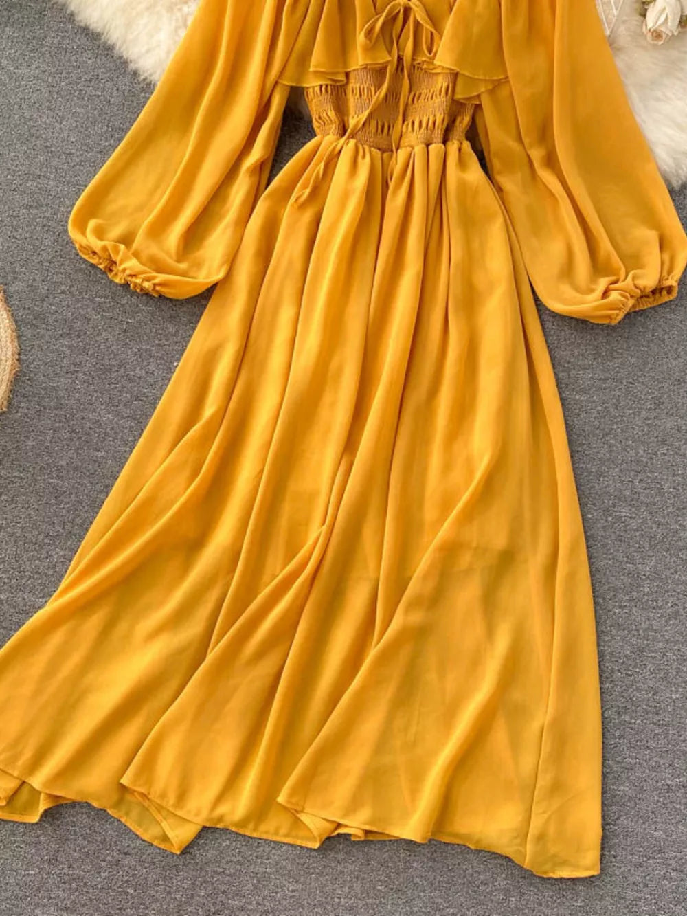 Yellow maternity dress with smocked bodice, ruffled square neck, and balloon sleeves.