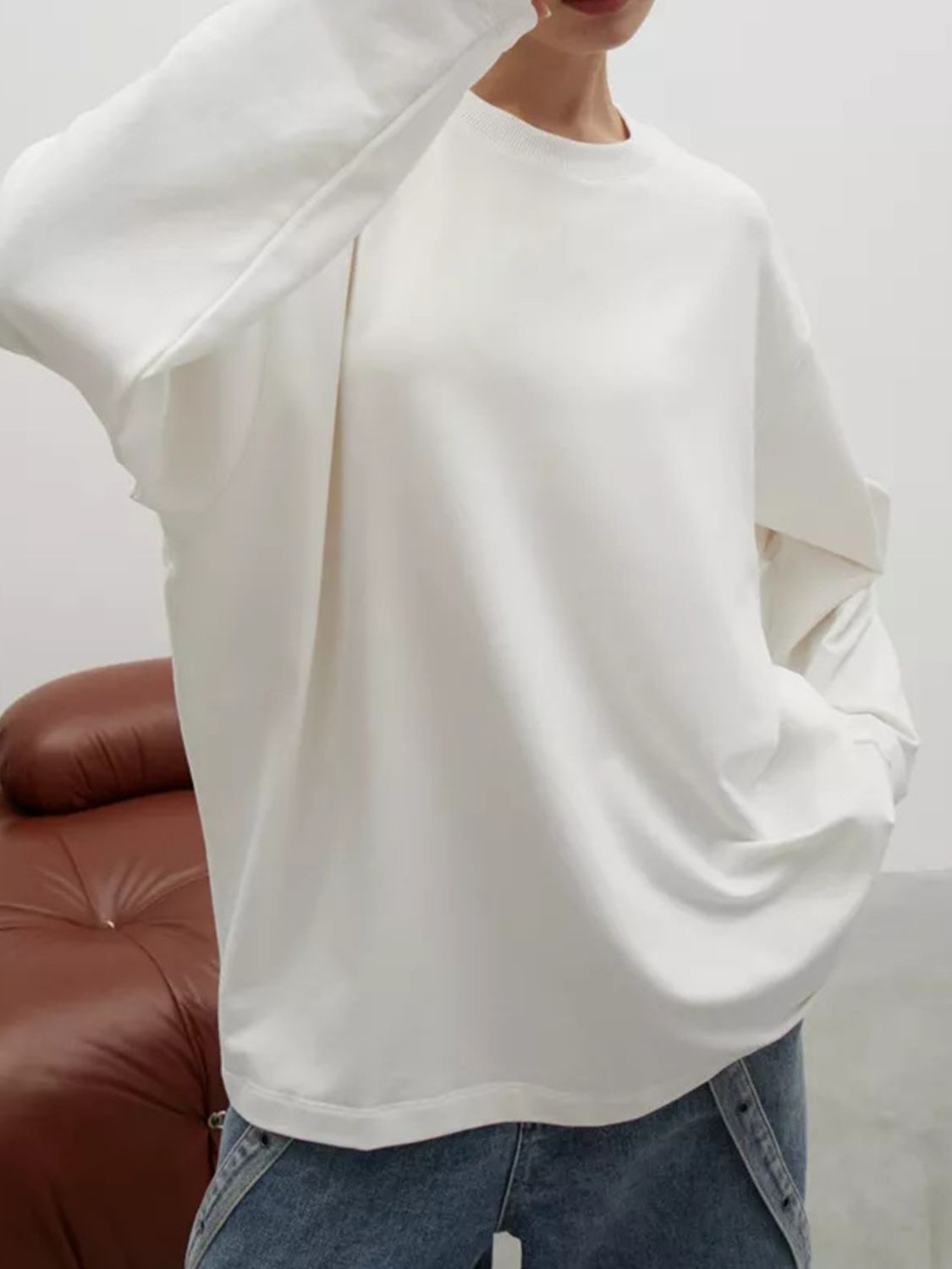 White oversized crewneck sweatshirt with voluminous sleeves and crew neckline.