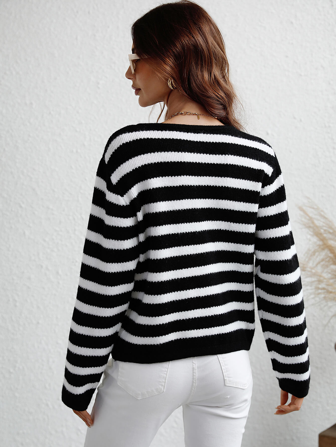 Black and white horizontal stripe knit cardigan with crew neck and long sleeves.