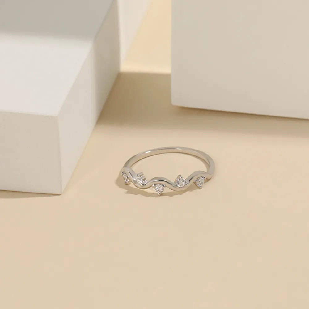 Silver band ring with wavy design and clear zirconia stones
