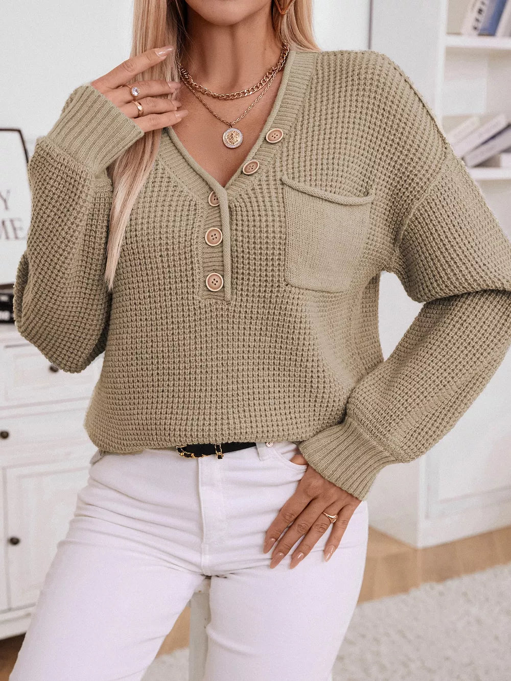 Relaxed knit sweater in tan with button detail, V-neck, and chest pocket.