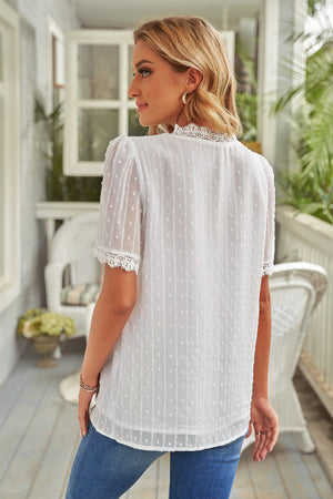 White dotted swiss blouse with lace trim and short sleeves.