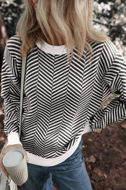 Chevron knit crewneck sweater in black and white with white trim.
