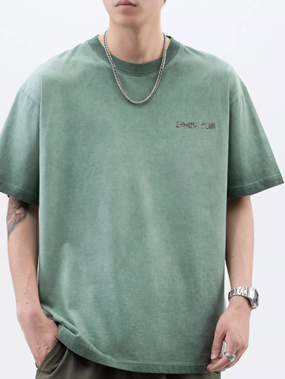Vintage green cotton t-shirt with a subtle lettered graphic on the chest and a relaxed fit.