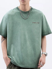 Vintage green cotton t-shirt with a subtle lettered graphic on the chest and a relaxed fit.