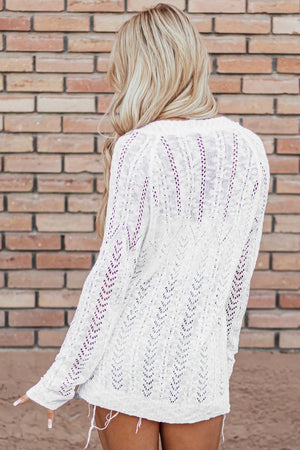 White openwork chevron knit cardigan with open stitch detail and long sleeves.